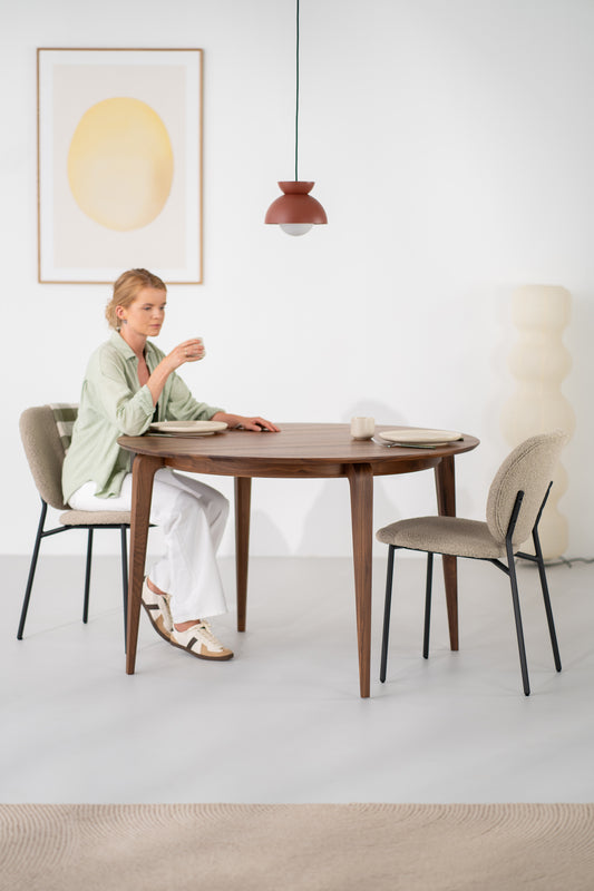 Round solid walnut dining table seen from above, showing natural grain pattern across the 120 cm top