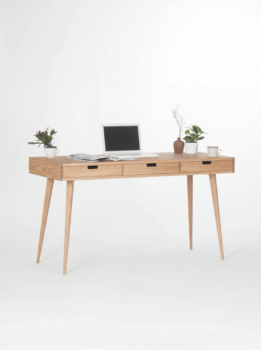 HEIM 140 home office desk in oak wood, angled view with three wooden drawer fronts, a laptop and two plants