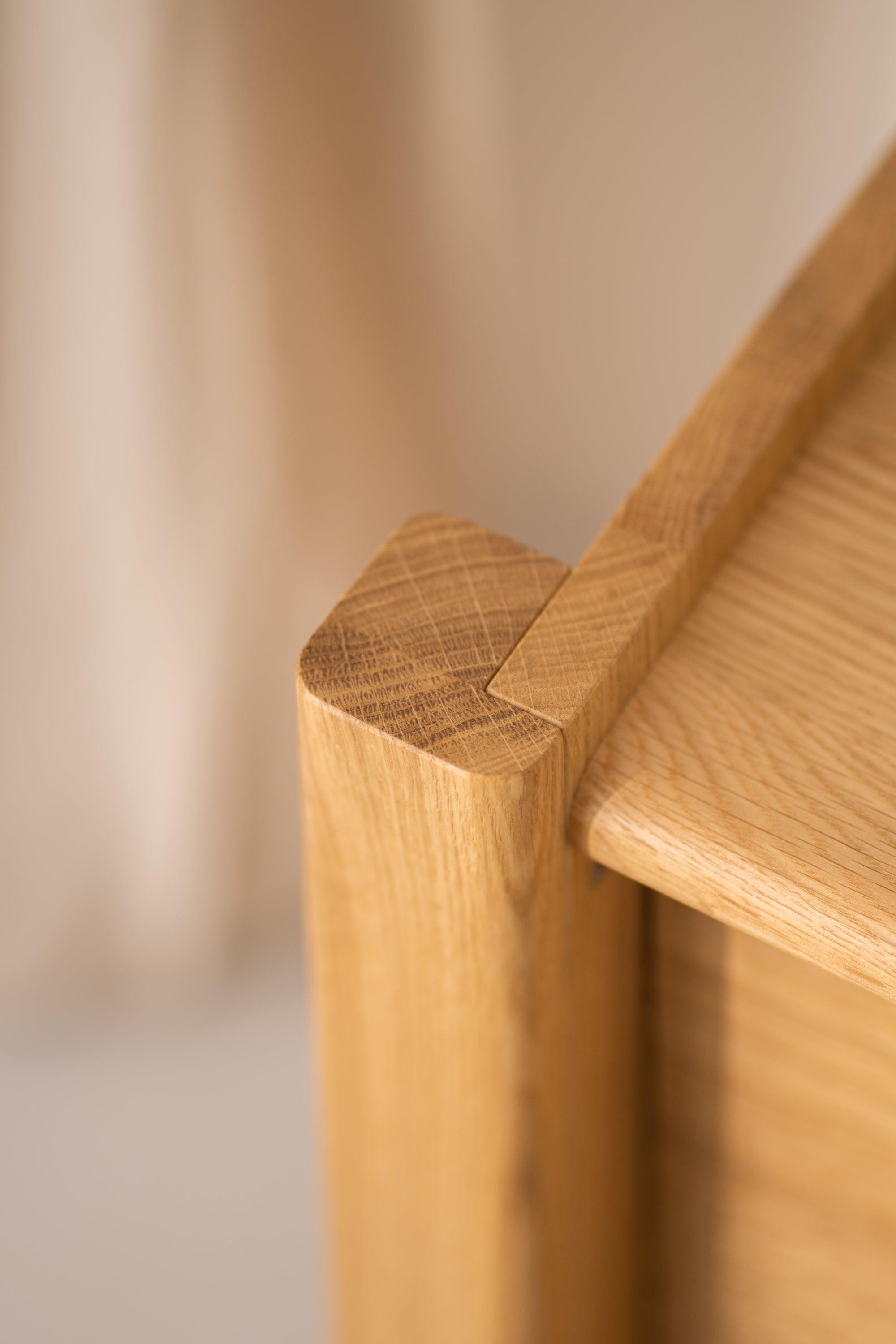 Close-up of a wooden furniture joint with smooth, rounded edges.