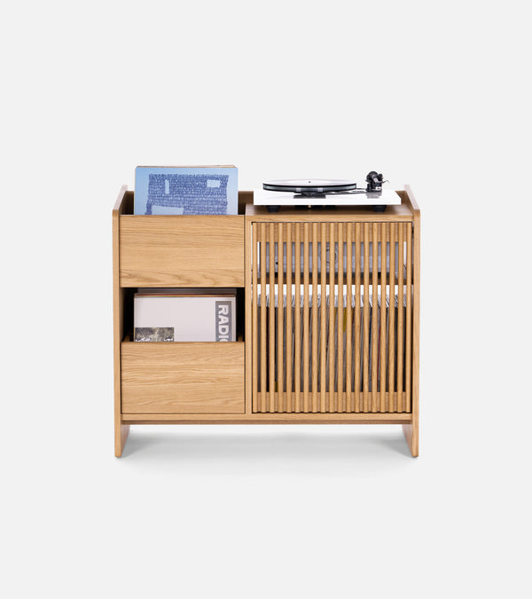 Wooden storage unit with vinyl records, a record player, and books on top.