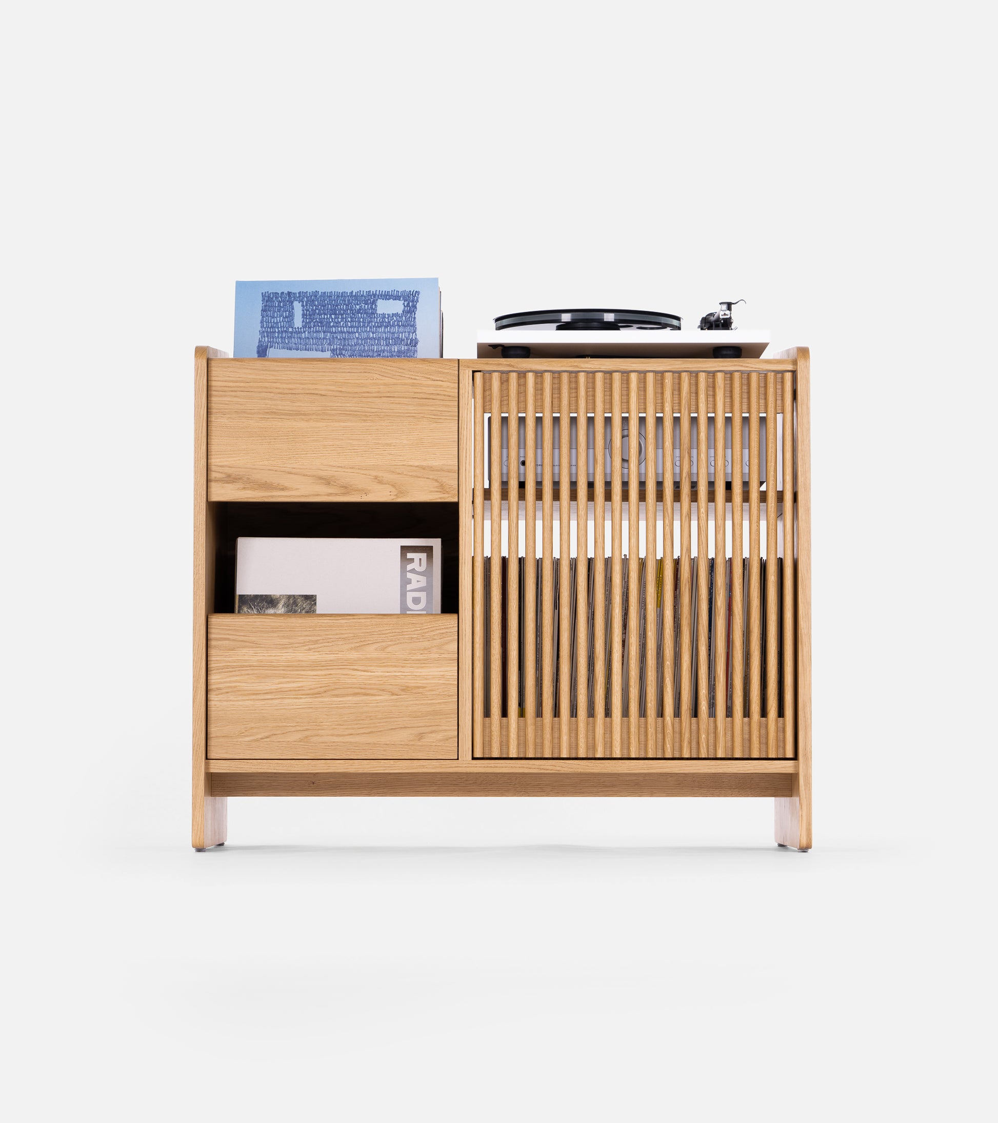 Wooden media cabinet with a vertical slat door, open shelves, and a record player on top.