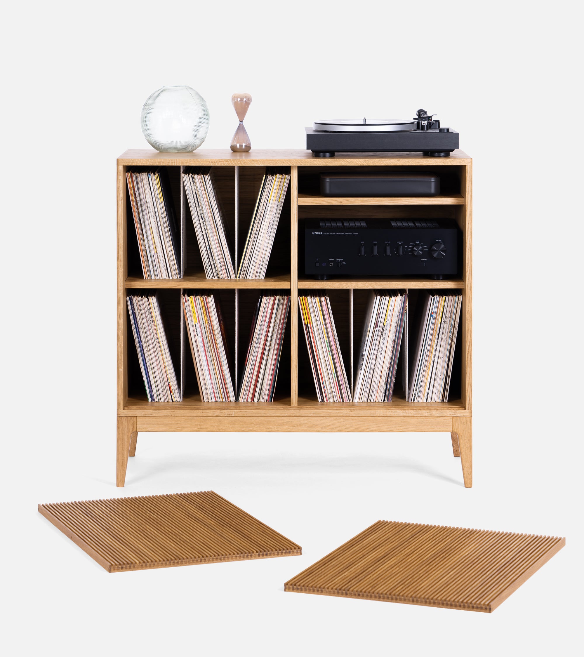 Wooden sideboard with drawers, vinyl records, a turntable on top, and books on the lower shelf.