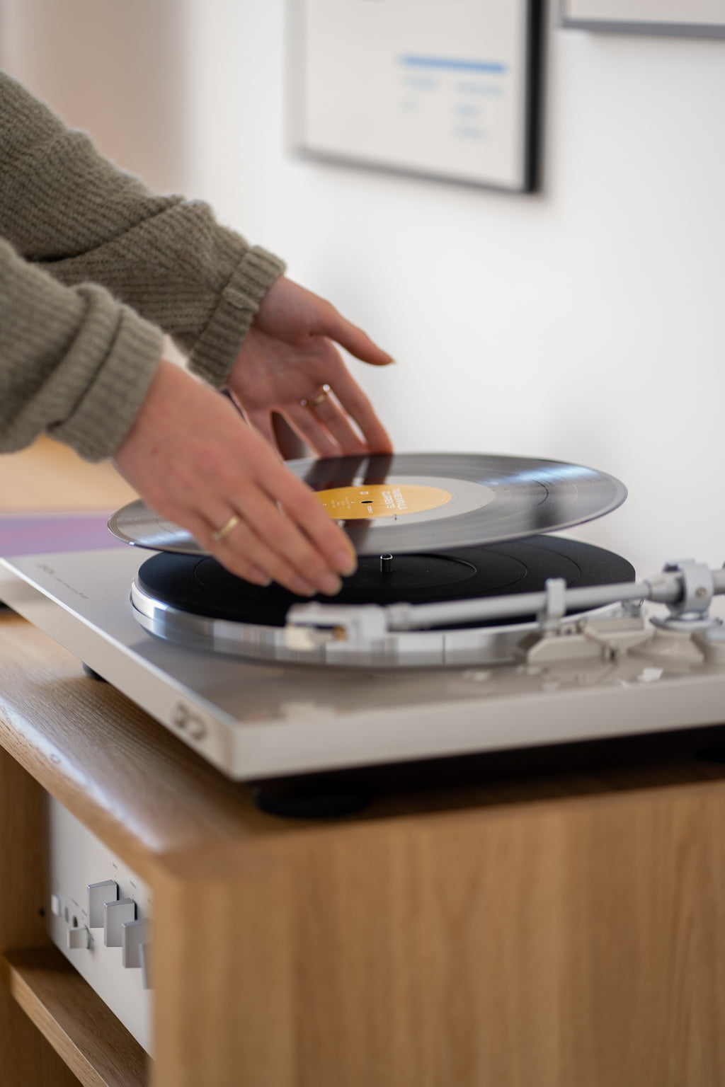 A person placing a vinyl record on a turntable.
