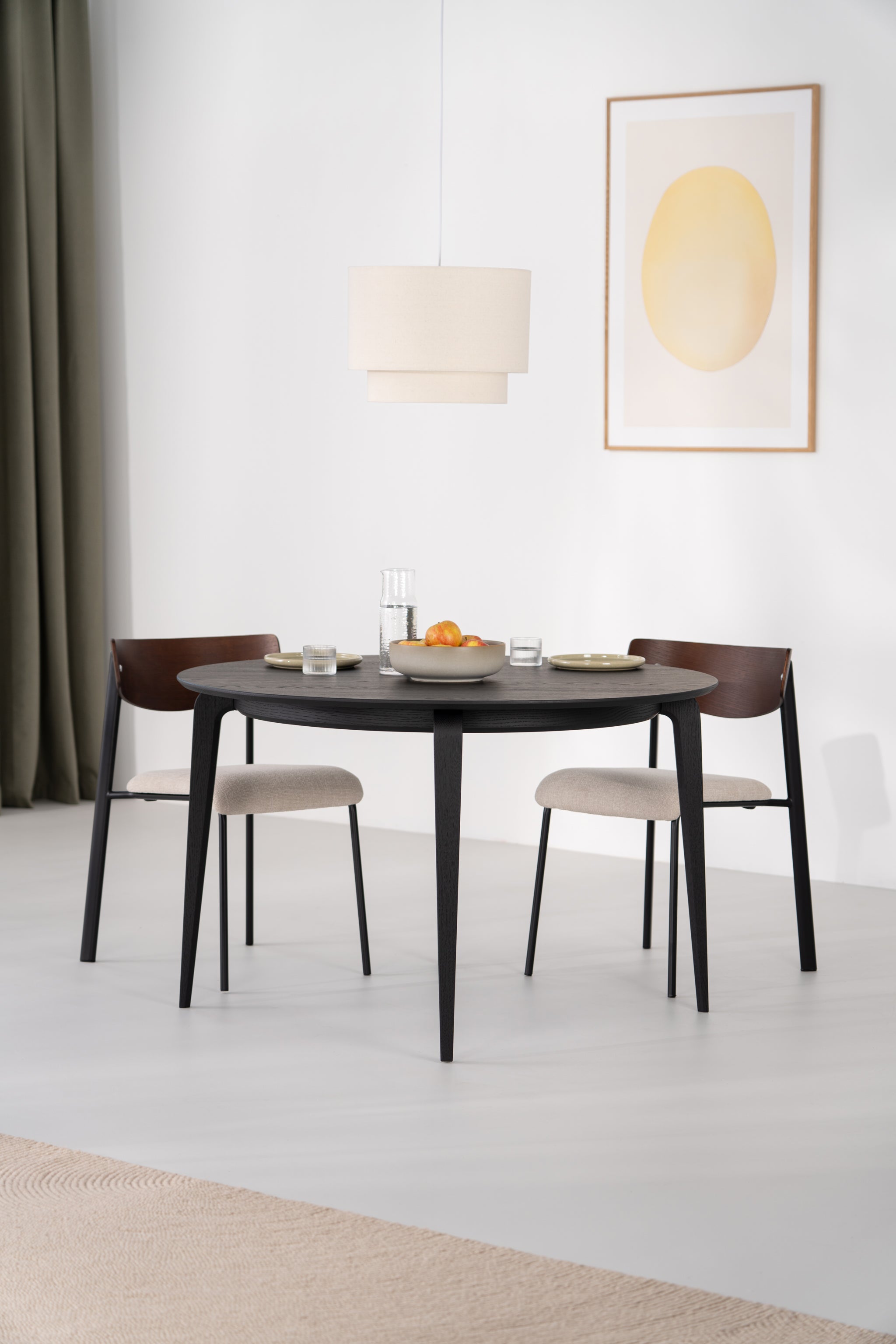 Mesa redonda YUKI de roble negro con vajilla blanca y mantel de lino sobre el tablero