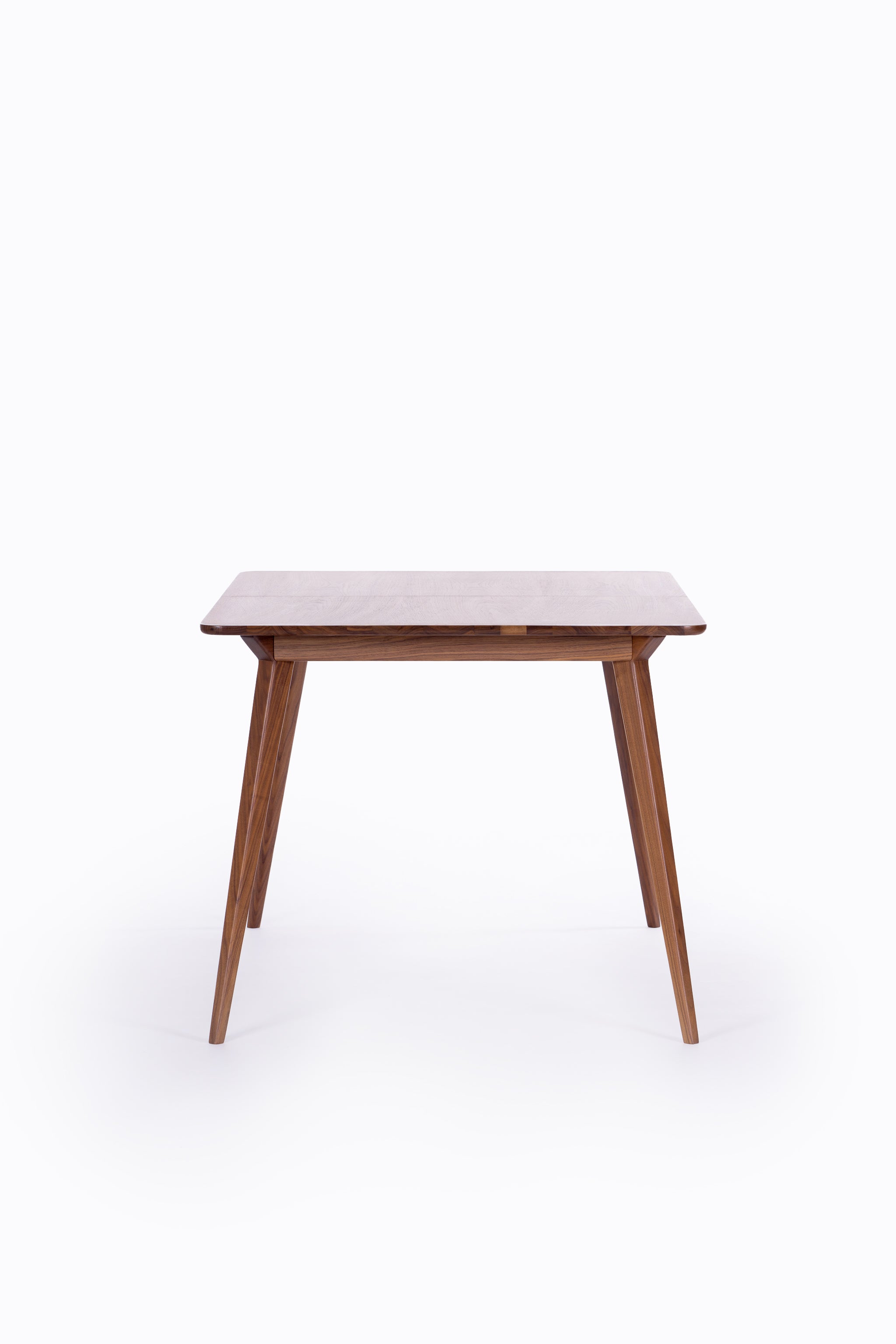 Wooden table with tapered legs on a white background.
