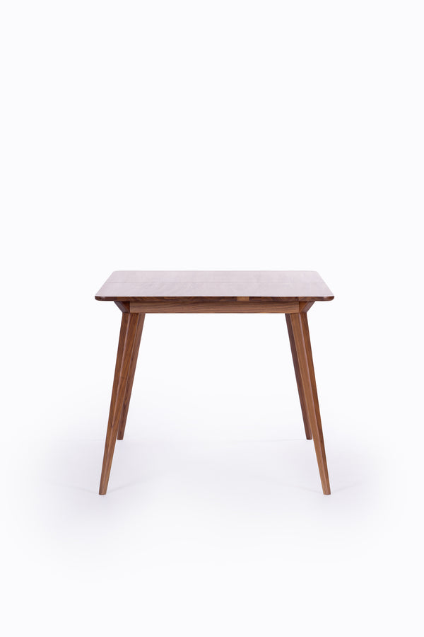 Wooden table with tapered legs on a white background.