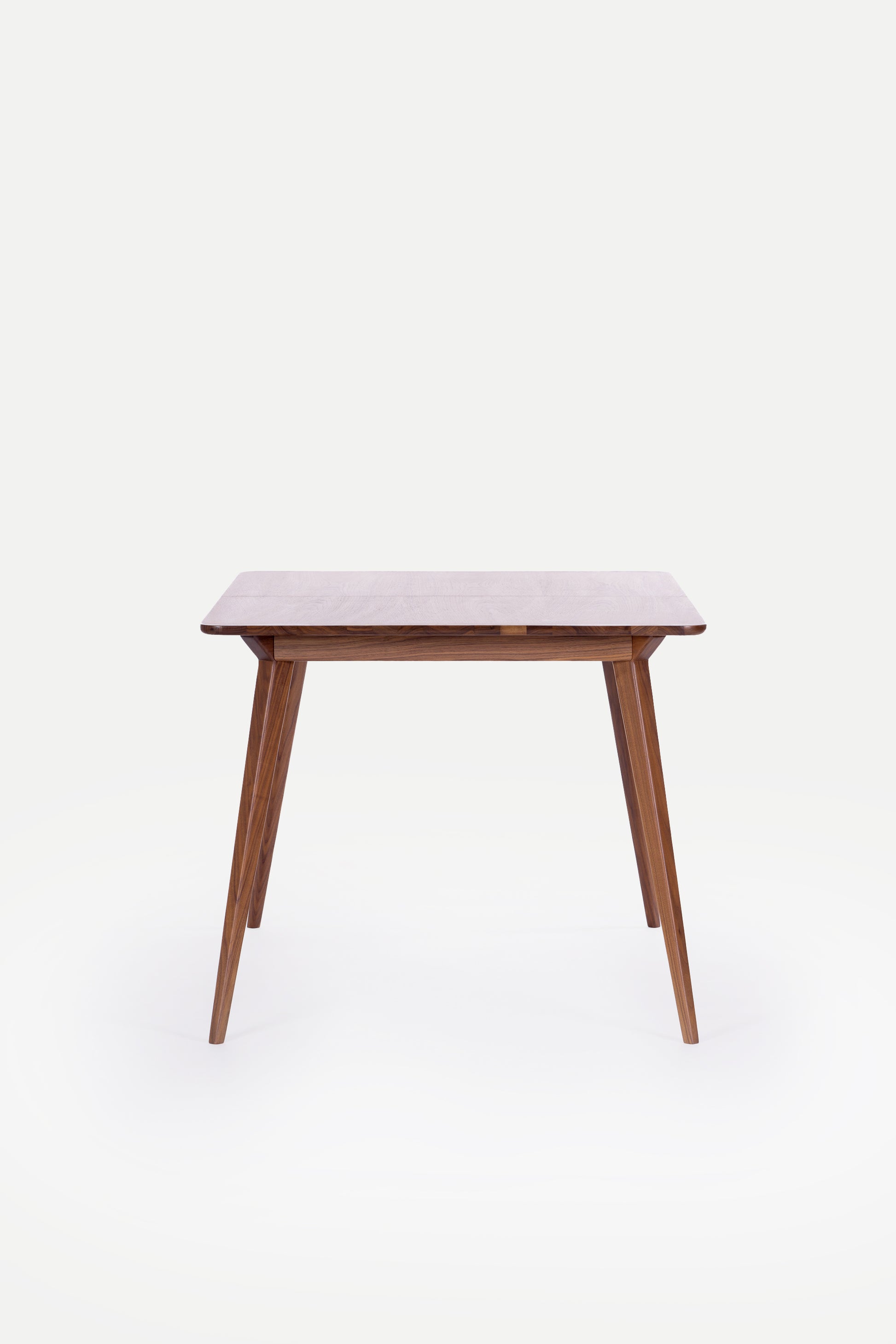 Wooden table with tapered legs on a white background.