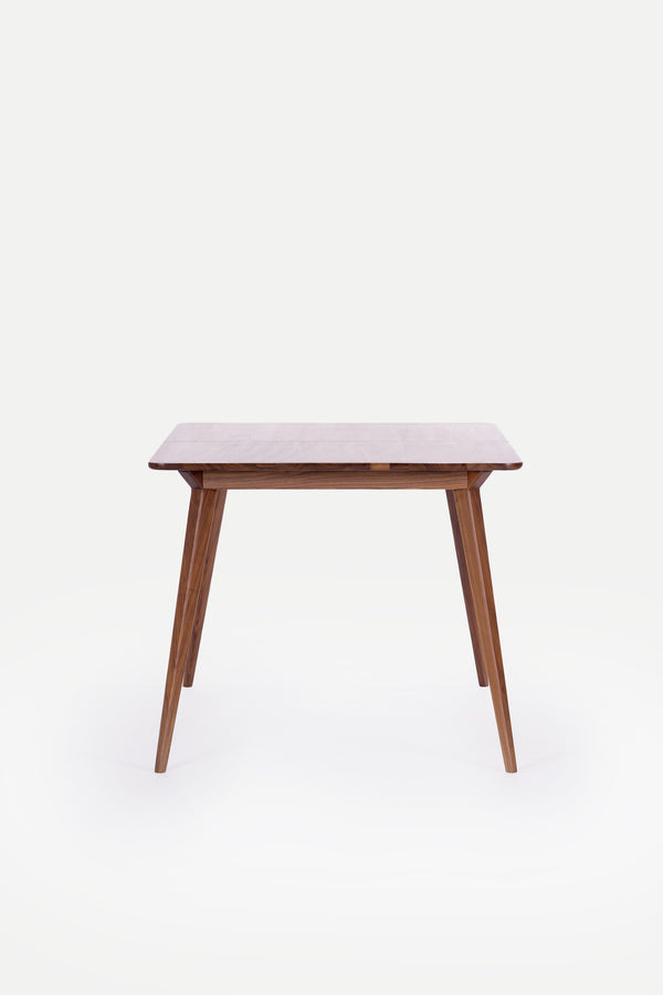 Wooden table with tapered legs on a white background.