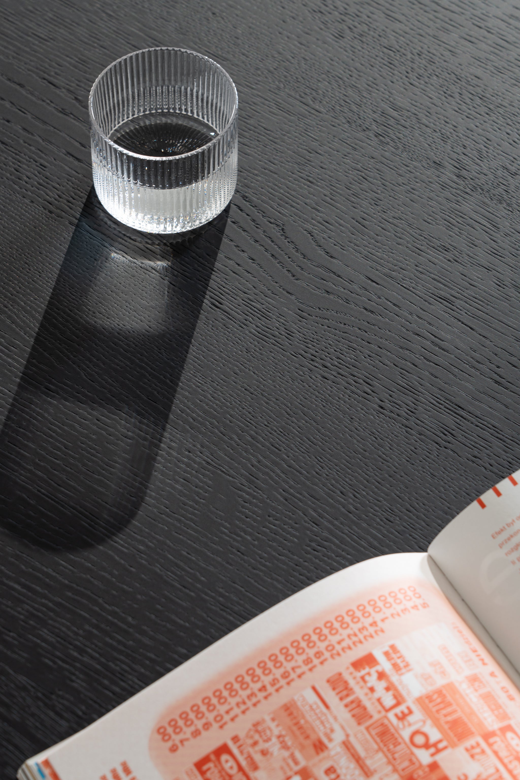 Close-up of the black oil-wax finish on the NOON coffee table surface with visible oak grain