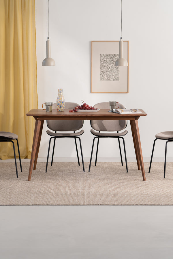 Modern dining table with chairs, pendant lamps, and decor items like a vase and grapes. Yellow curtain background.