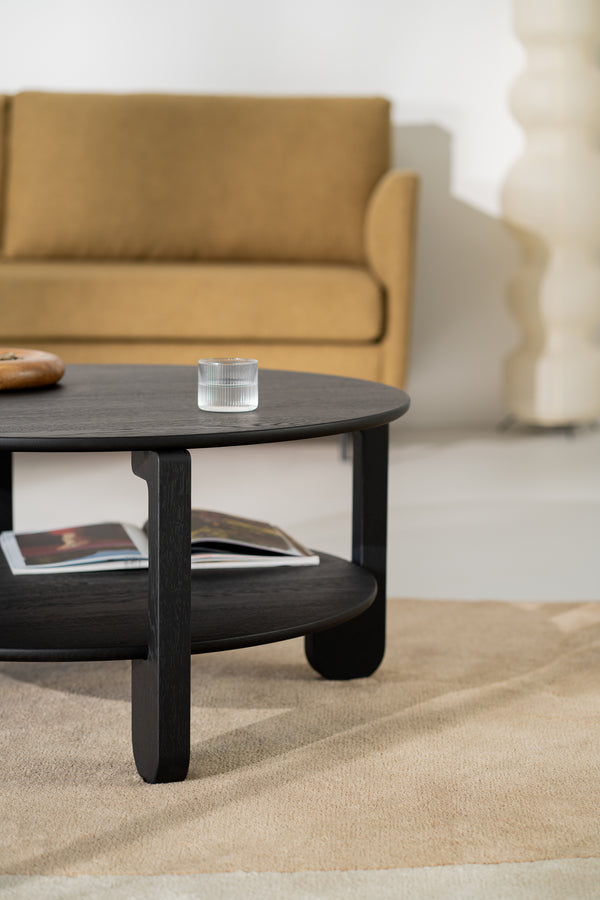NOON round table with a ceramic vase and book on top, seen from a seated angle