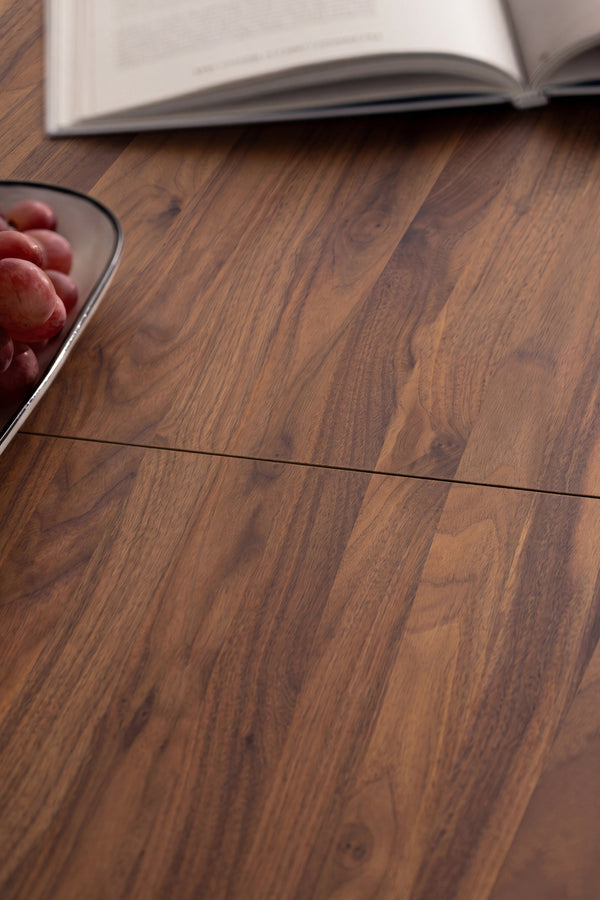 Open book and bowl of grapes on a wooden table.