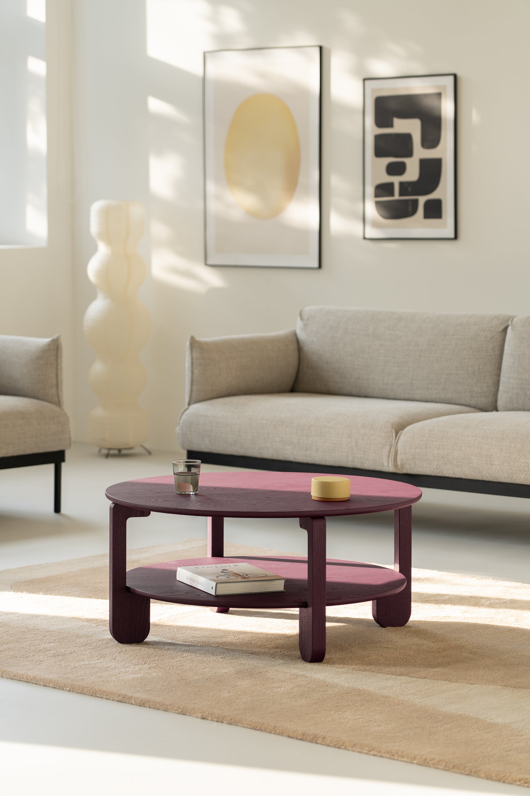 Hand resting on the NOON burgundy tabletop to show the scale and tactile matte texture