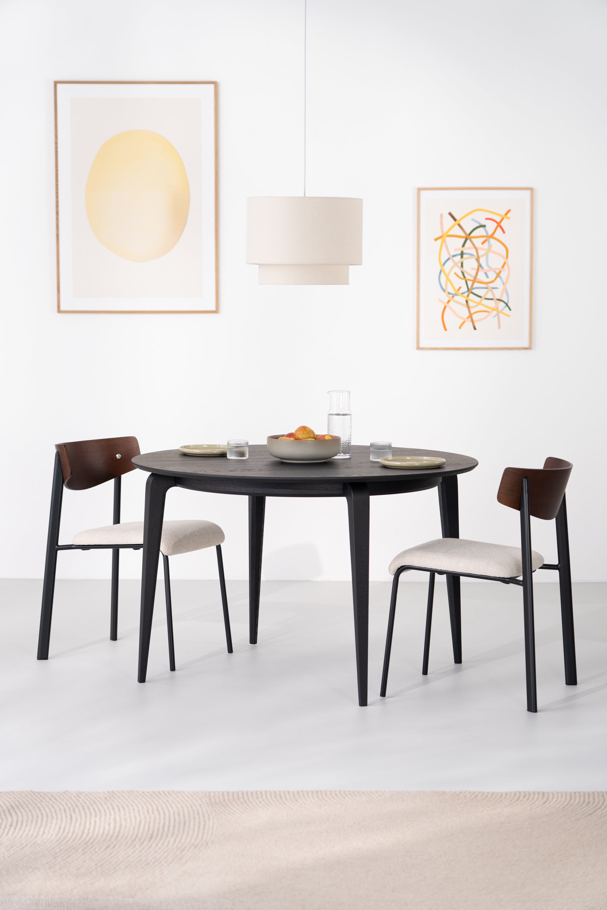 Natural light falling across matte black oak surface of YUKI round table