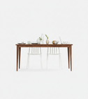 FARM rectangular dining table in solid American walnut, front view with two white chairs, vases and a laptop