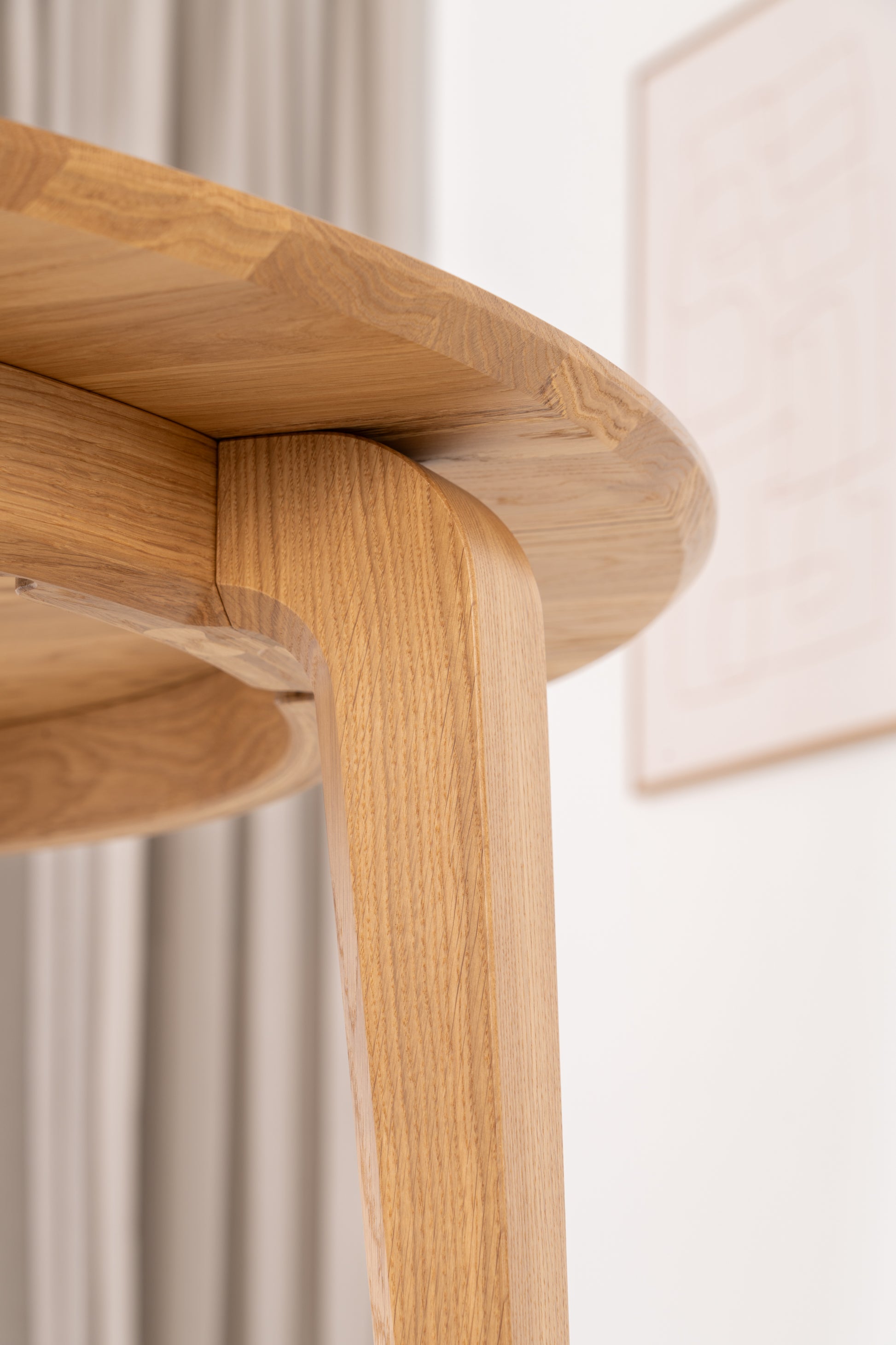 Top-down view of the round oak dining table with four chairs evenly spaced around it