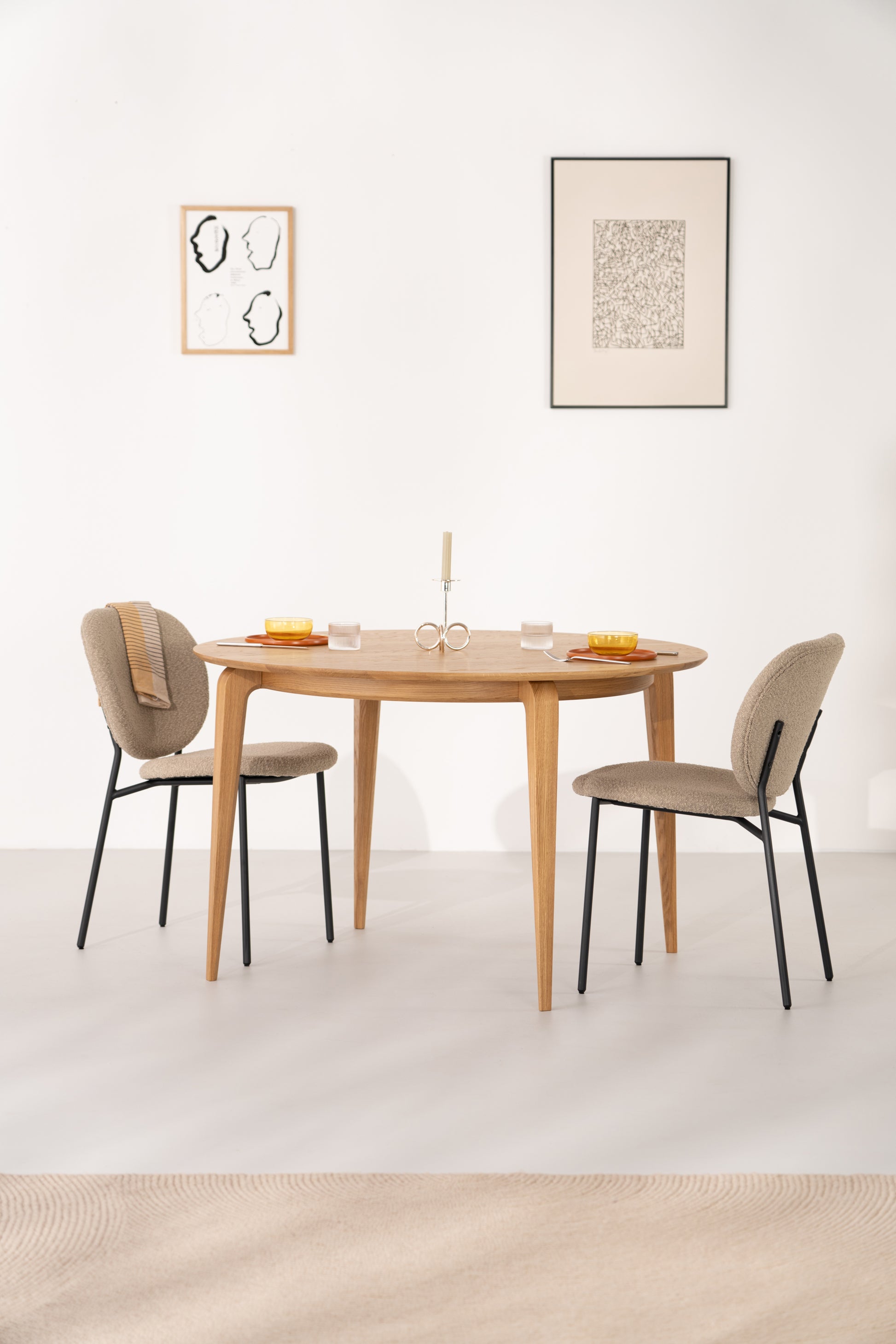 The YUKI round dining table against a white wall, natural light across the oak grain