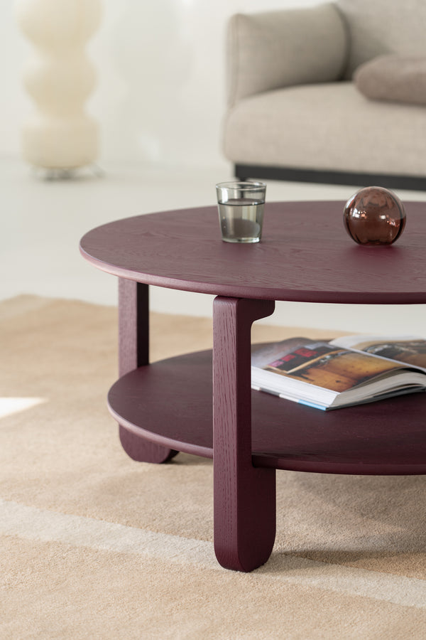 NOON burgundy round table styled in a living room with a neutral sofa and wool rug