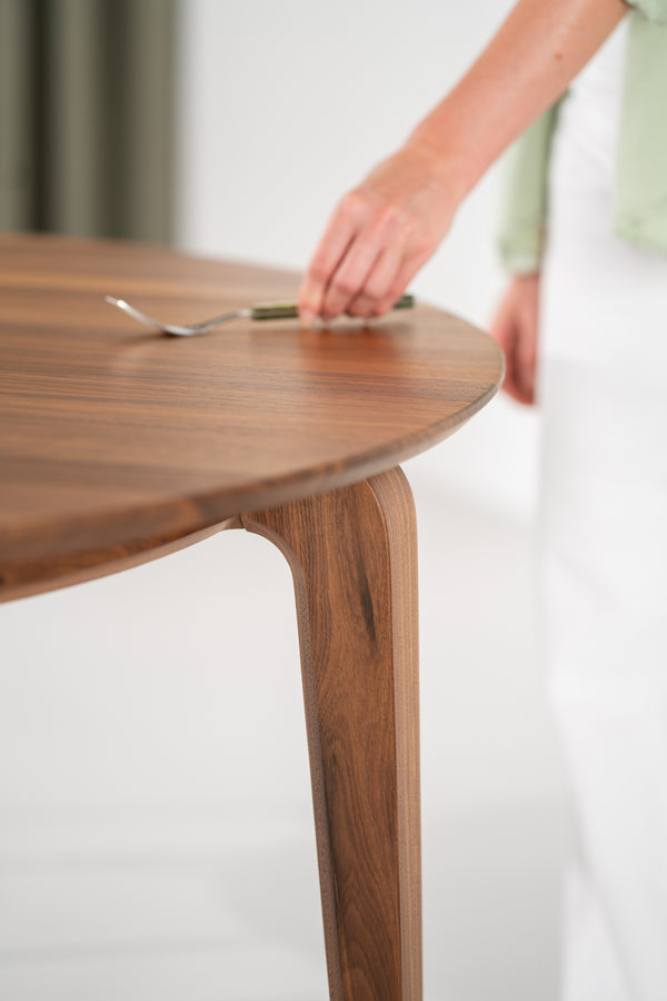 Vista completa de la mesa redonda YUKI en comedor minimalista con suelo de madera