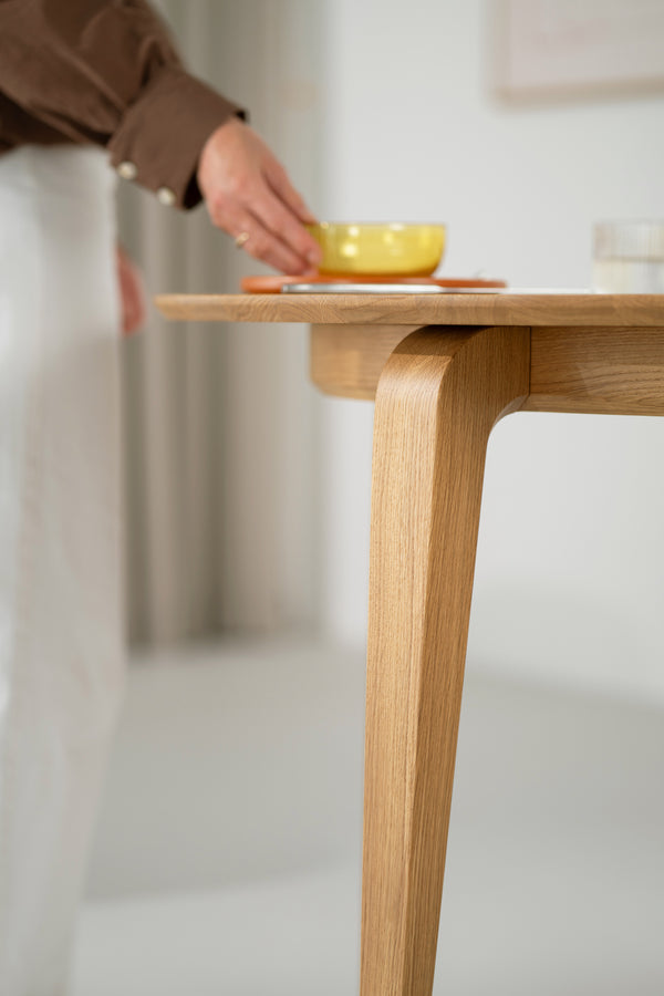 Close-up of the YUKI table edge, showing the rounded solid oak profile and oil-wax texture.