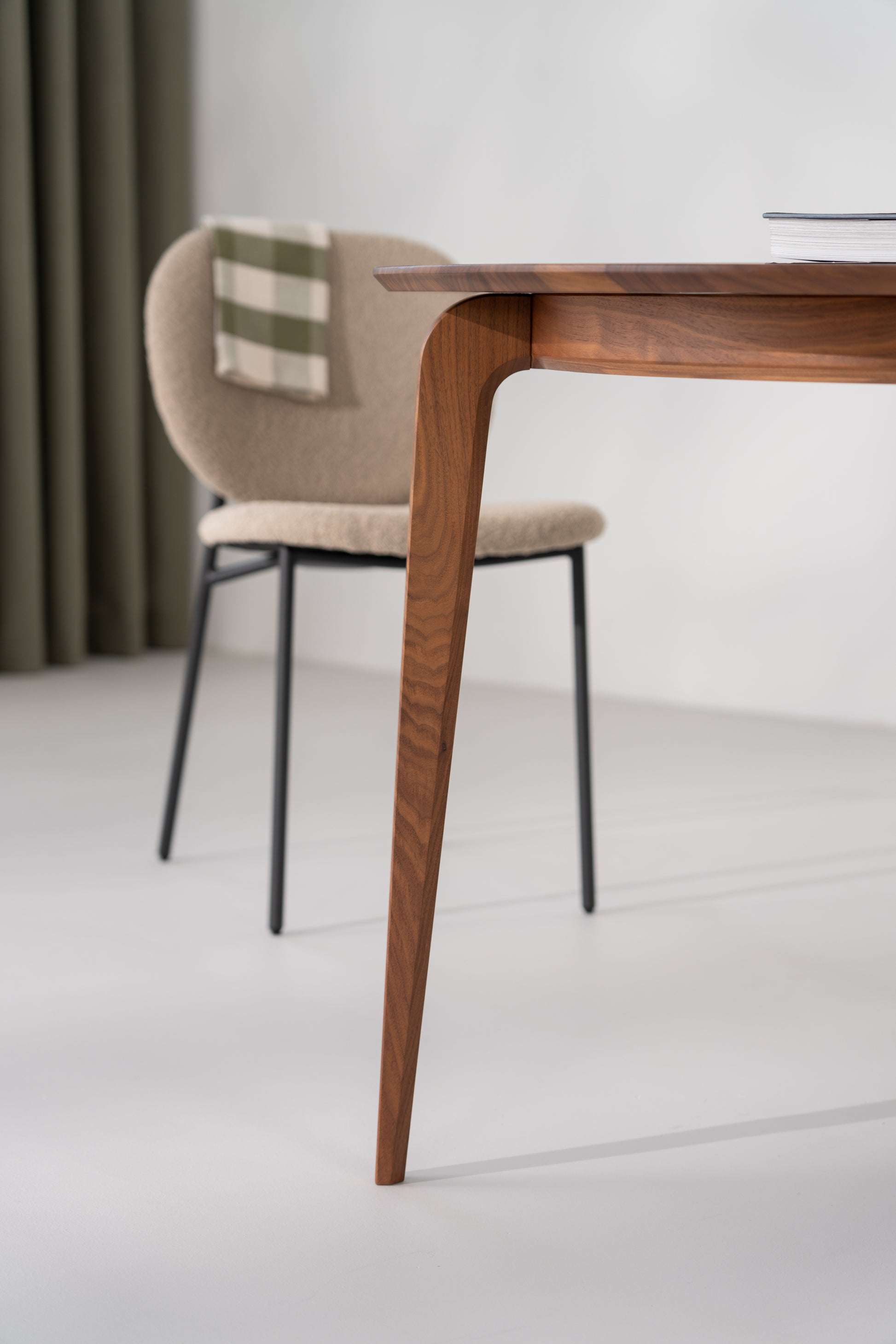 Angled view of solid walnut round table with light casting soft shadows on the top