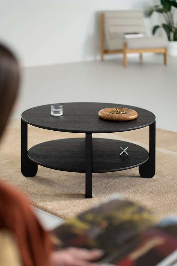 NOON black oak coffee table placed on a textured rug in a Japandi-style interior