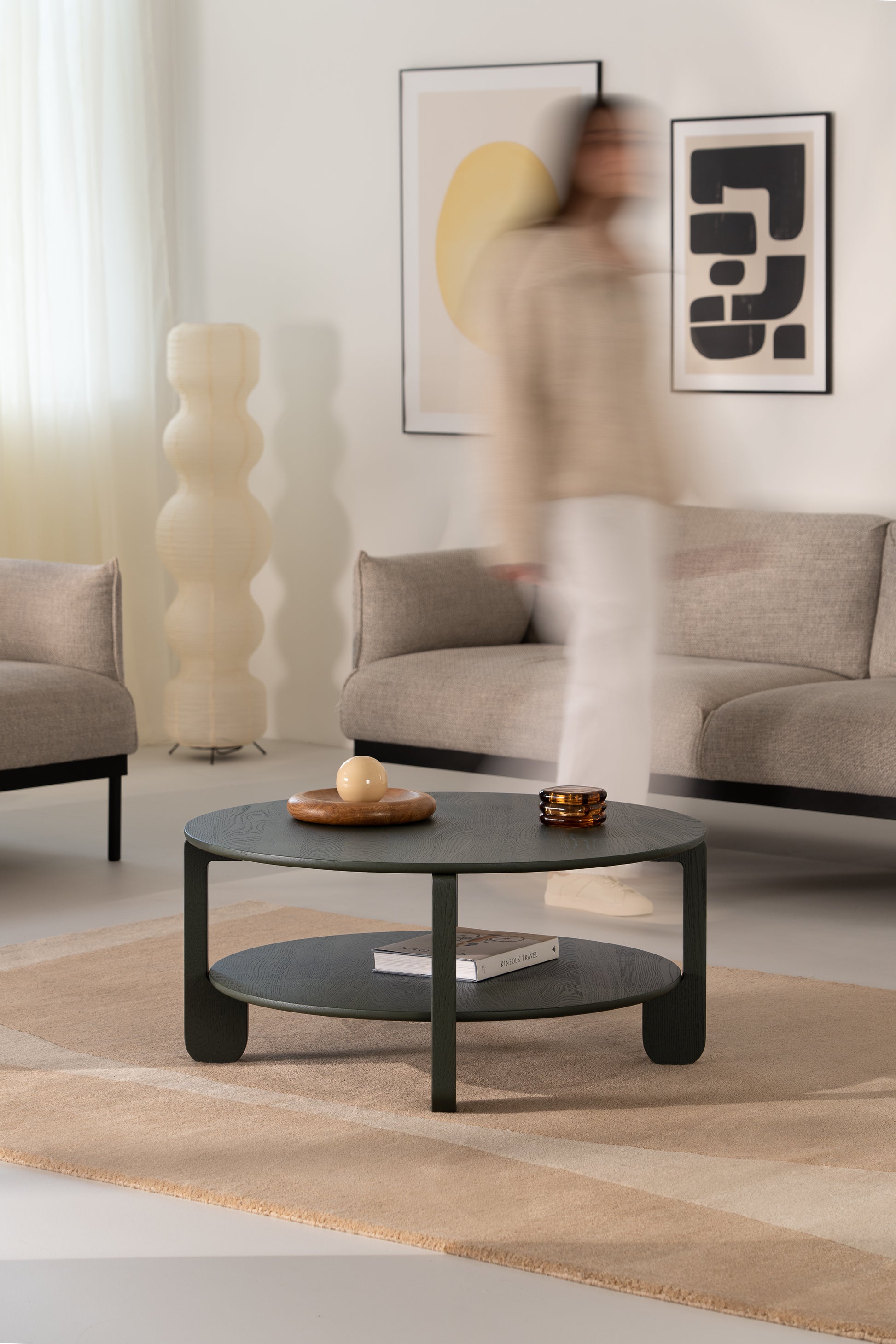 Top-down view of the NOON round tabletop with matte dark green lacquer over solid oak