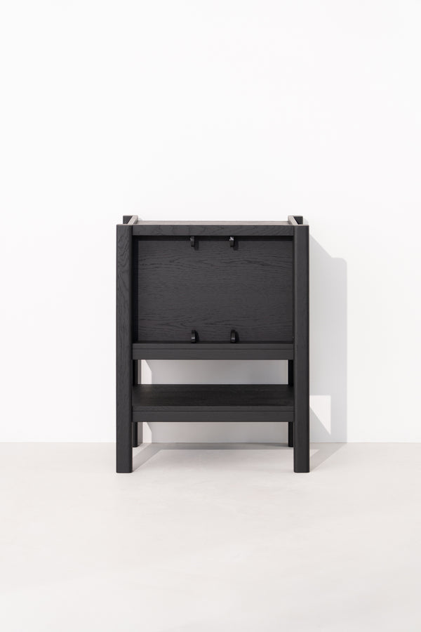 Black wooden chair folded flat against a white wall.