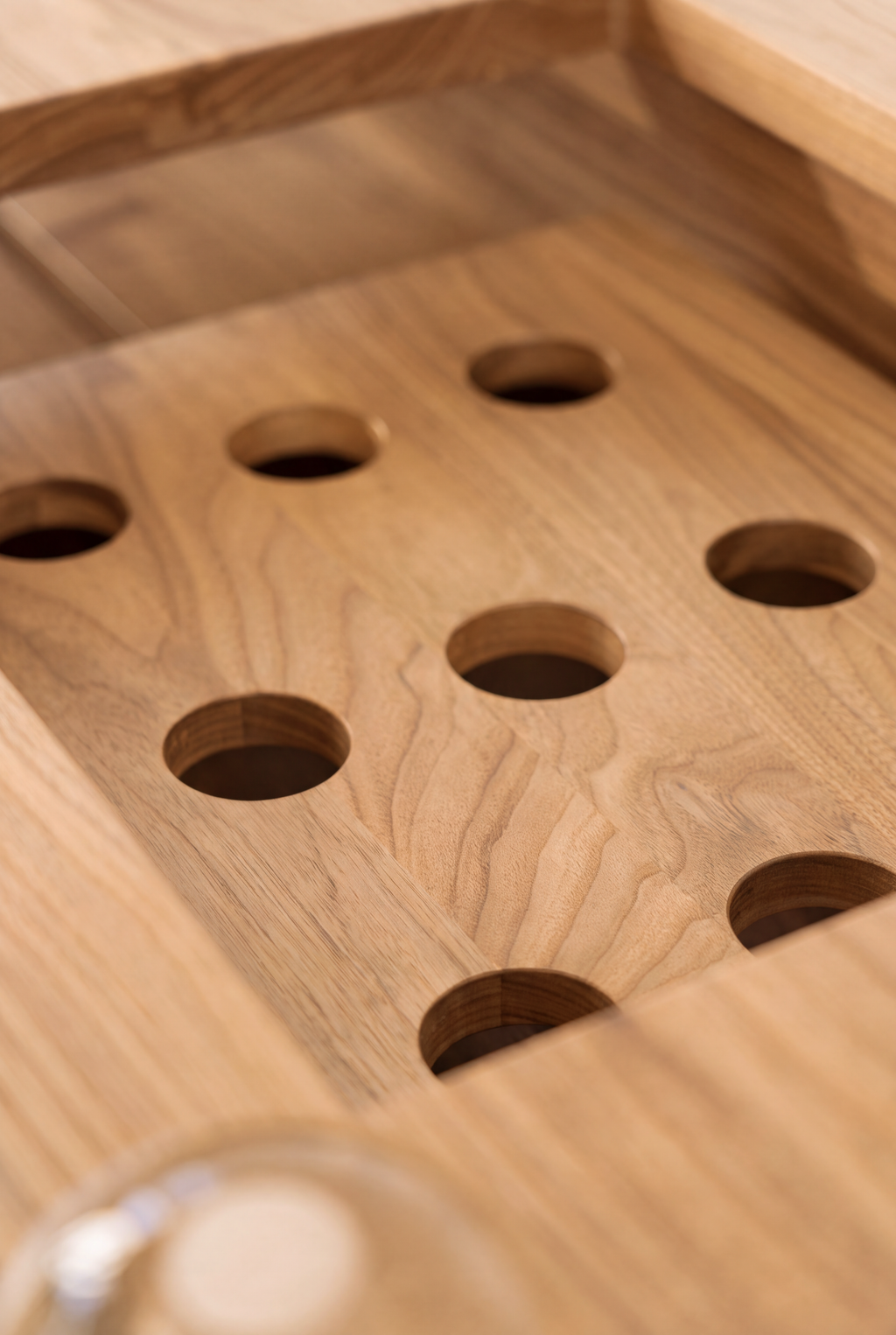 LOOP in solid oak, close-up of round ventilation holes in the wooden equipment platform set into the top frame