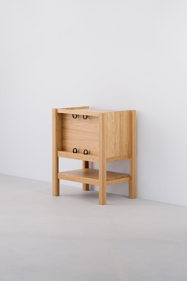 Wooden side table with open shelf and minimalist design against a white wall.
