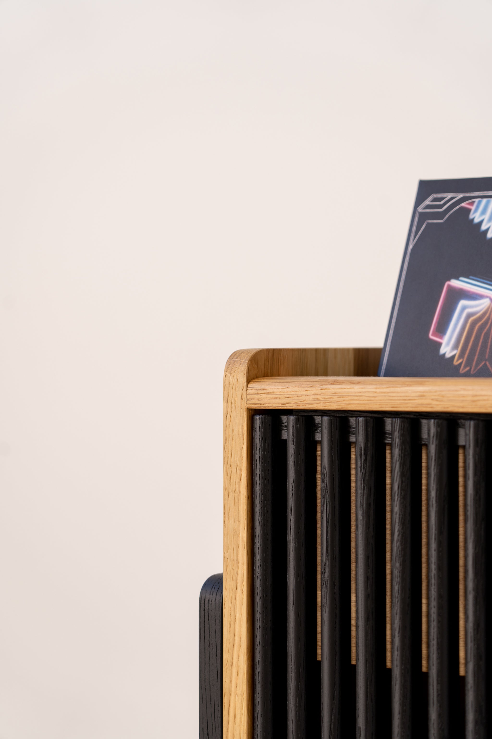 Wooden rack with black slats holding a colorful geometric design poster.