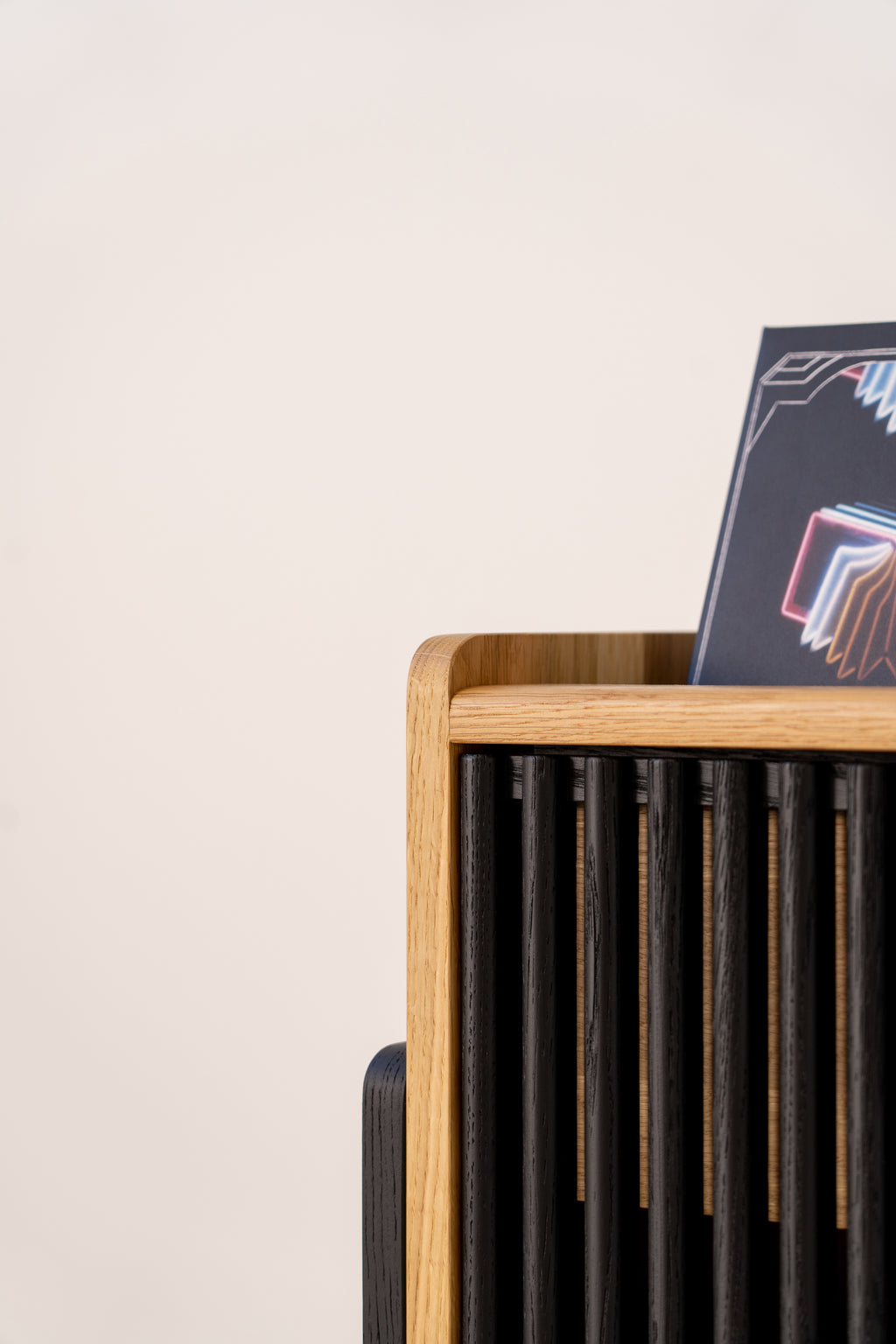 Wooden rack with black slats holding a colorful geometric design poster.