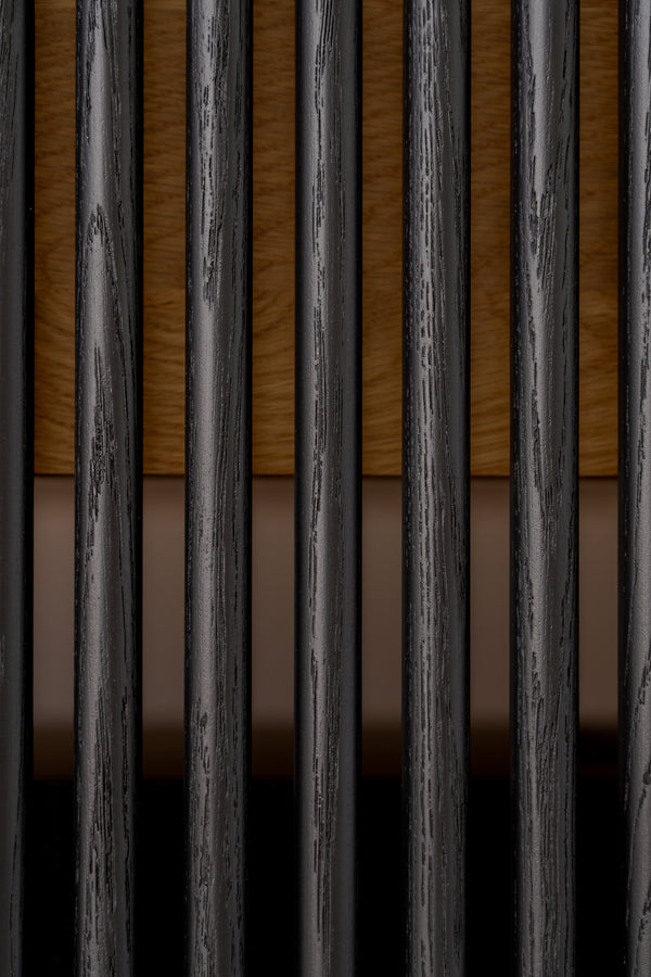 Close-up of vertical black bars with wood and a beige background.