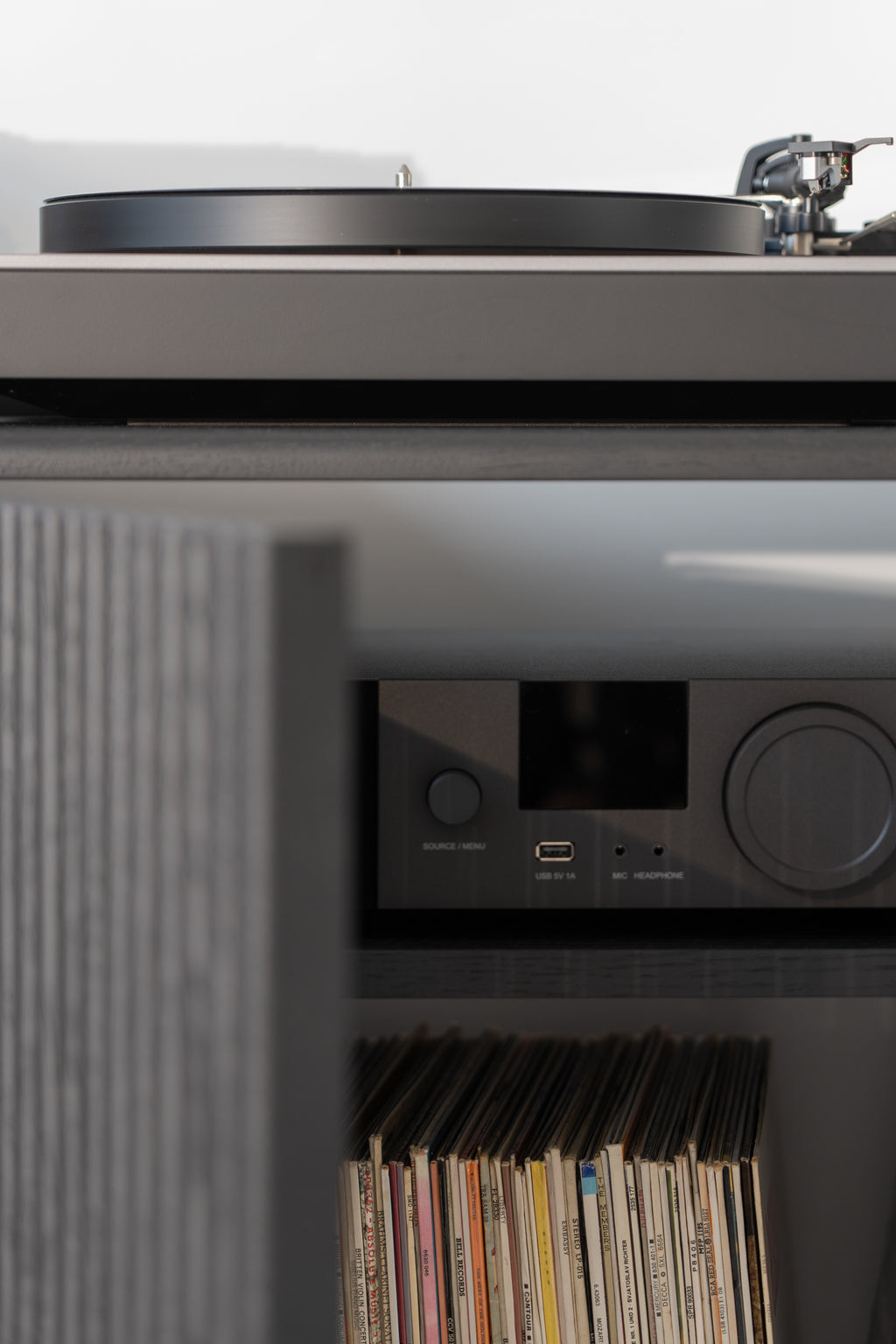 Turntable setup with vinyl records stored below.