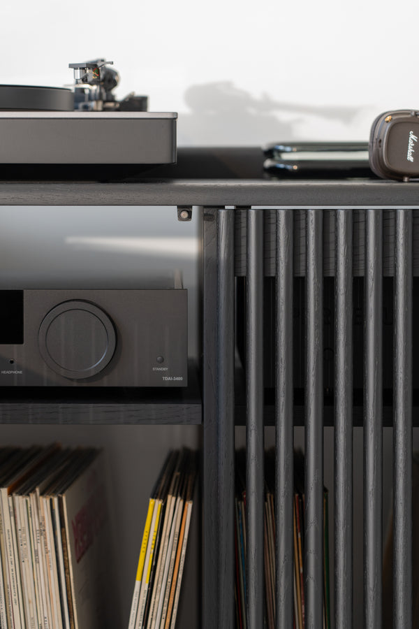 Turntable on a shelf with vinyl records and audio equipment below.