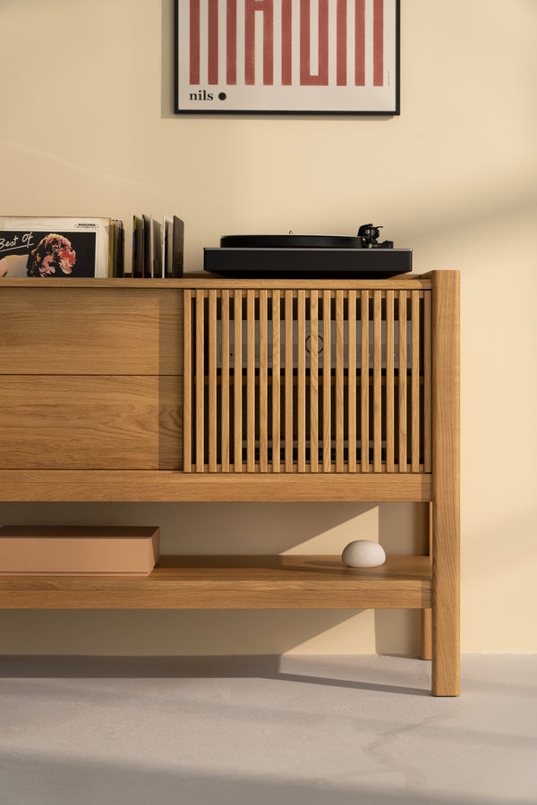  Wooden cabinet with vinyl records, a turntable, and a framed poster on the wall.