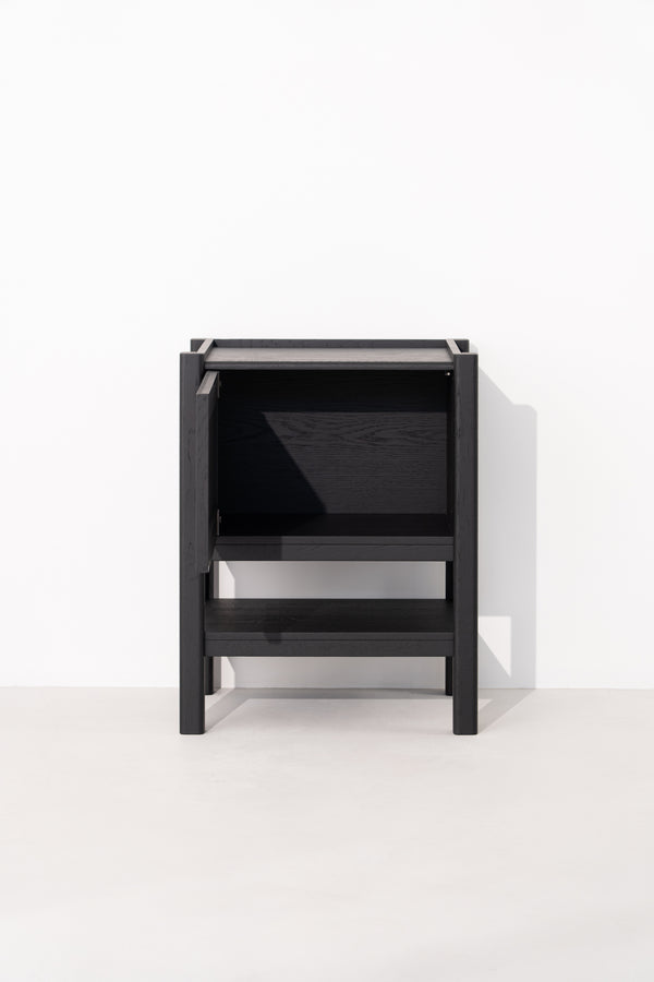 Black wooden cabinet with an open door and shelf on a white background.