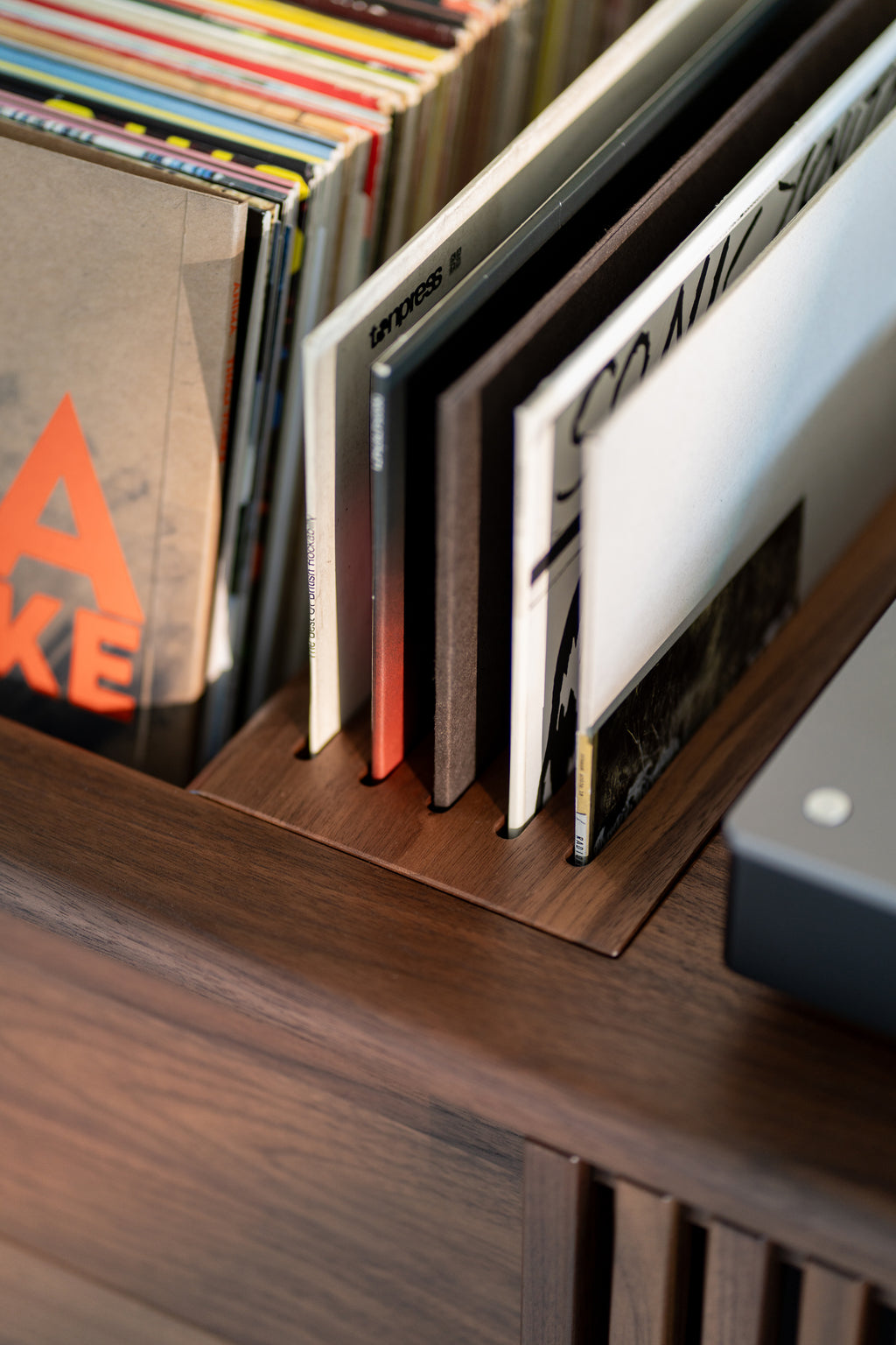 Vinyl records neatly stored in a wooden shelf.