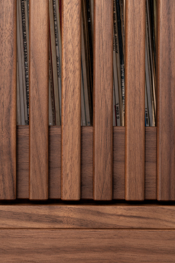Close-up of wooden slats with vinyl records visible between them.