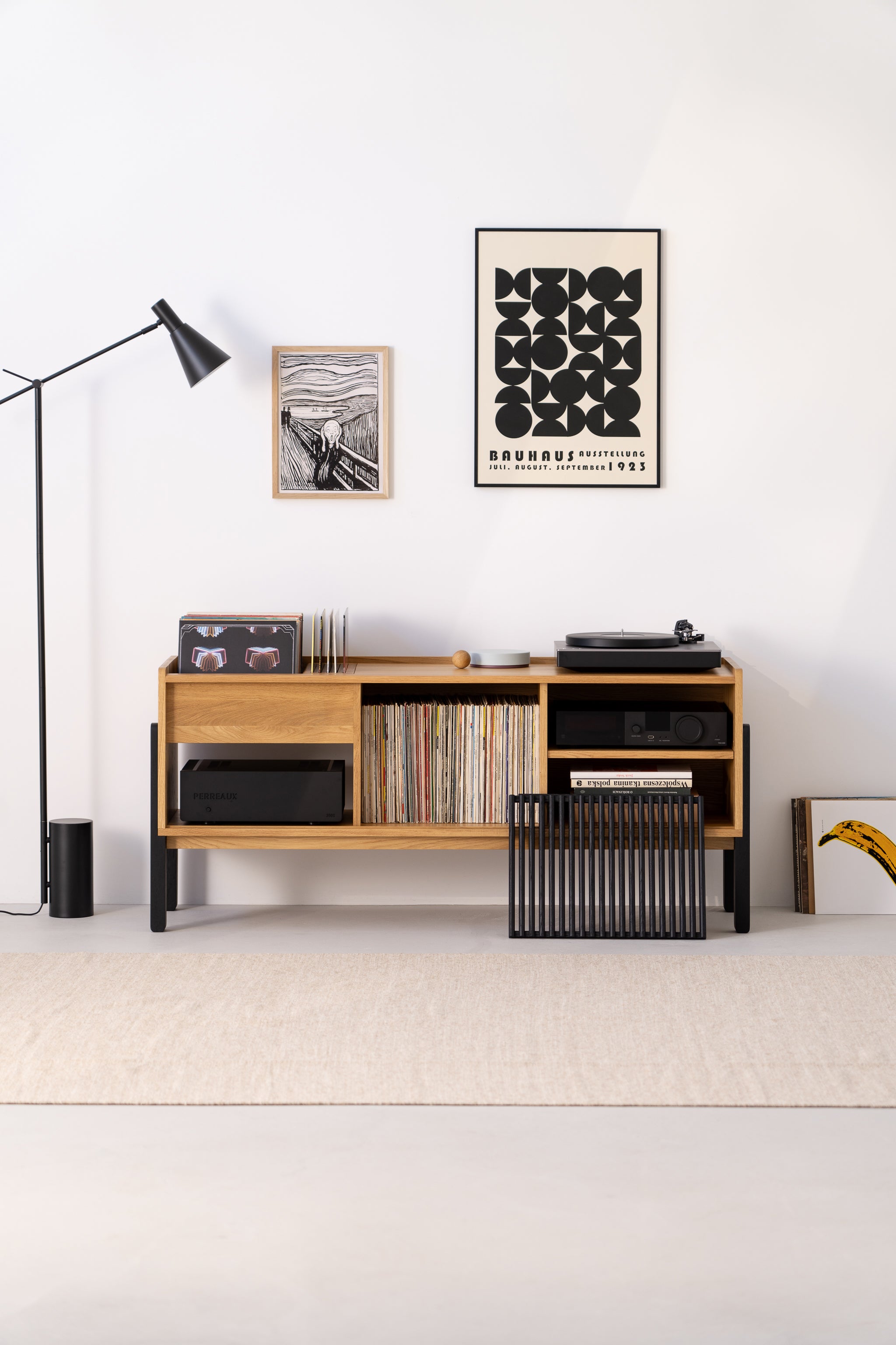Minimalist room featuring a wooden console, vinyl records and modern wall art - a cozy space for music lovers.