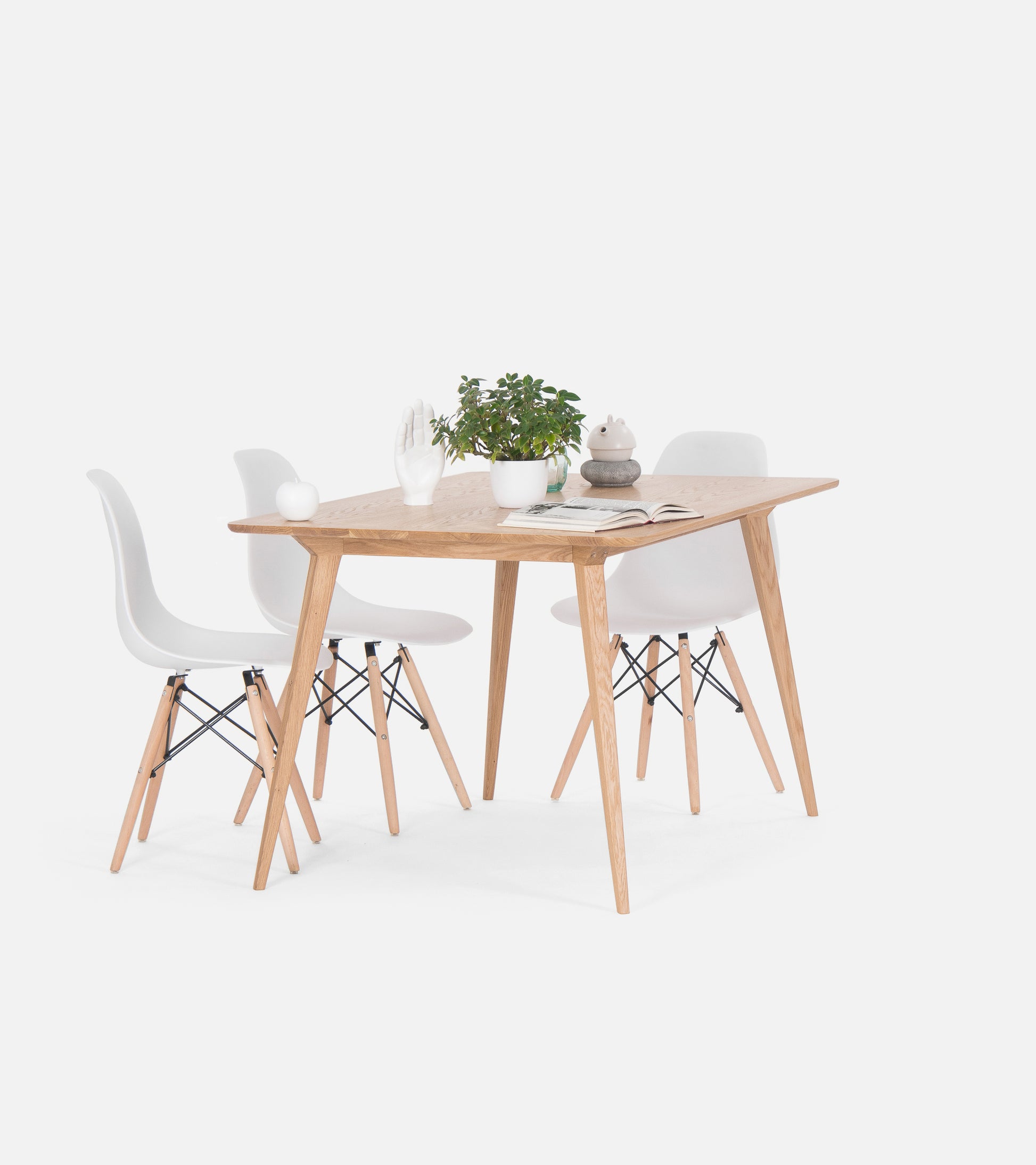 Wooden table with white chairs, a potted plant, and decor items on top, set against a plain white background.