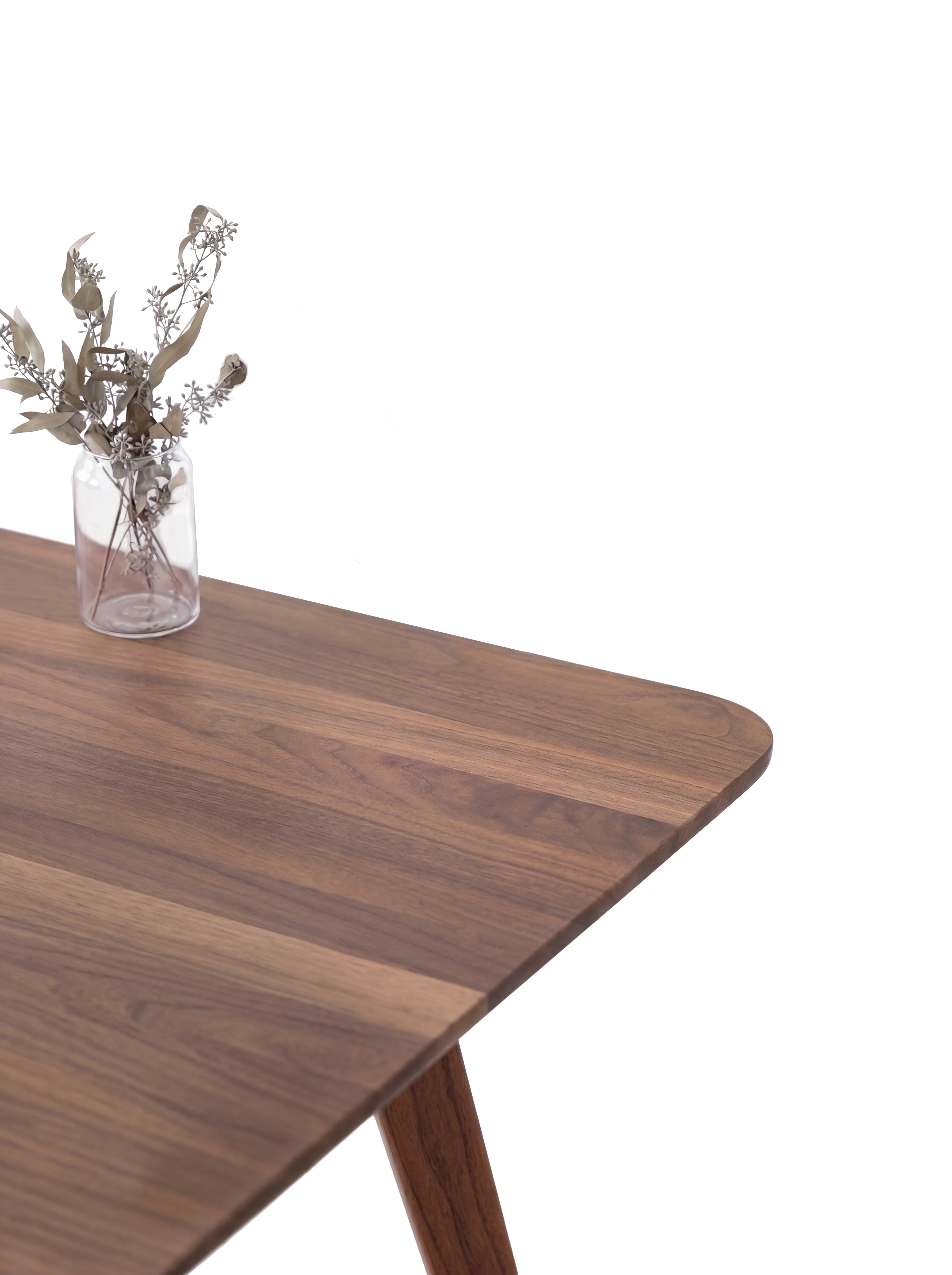 Wooden table with plant and a white background.