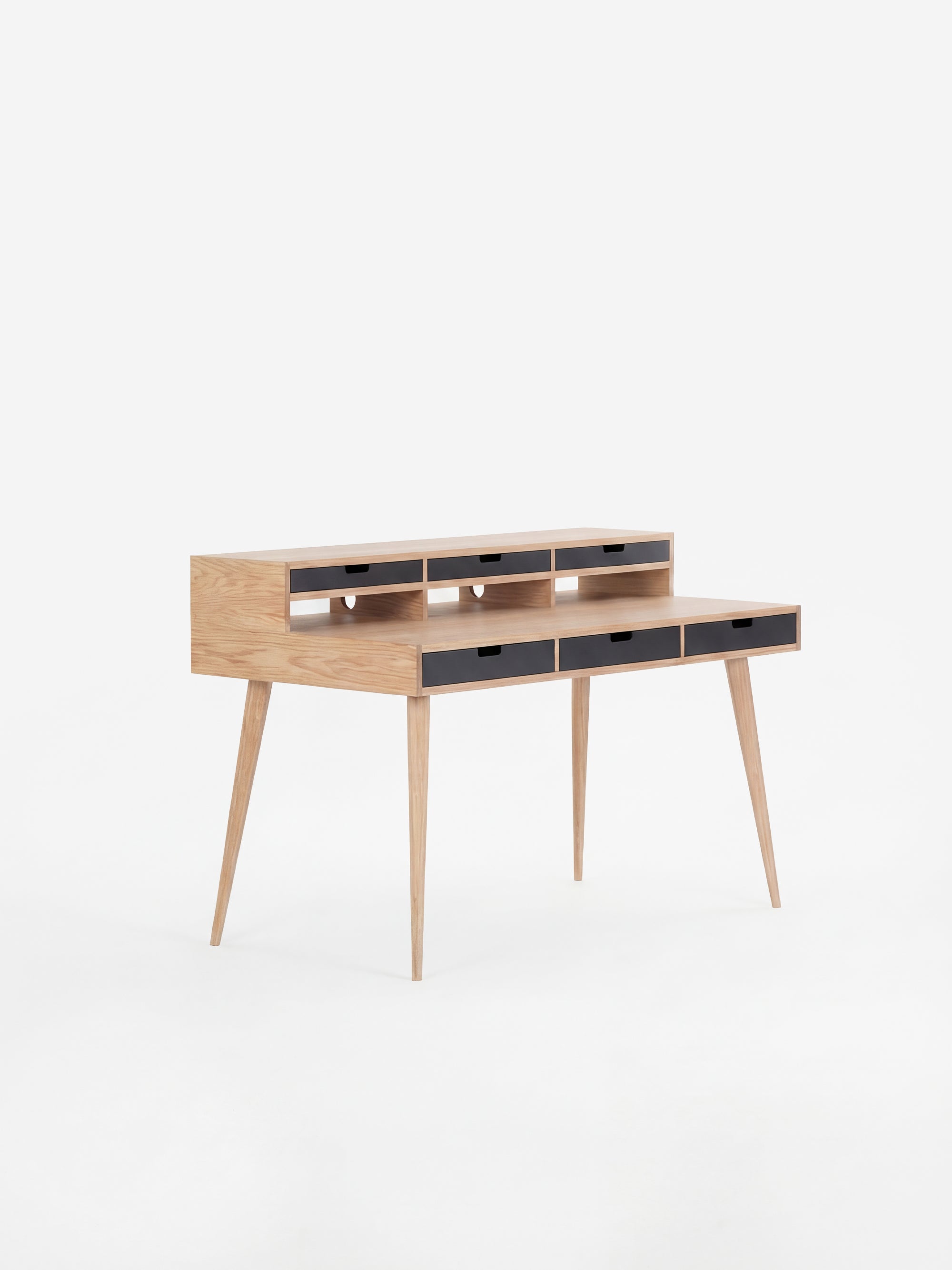 Wooden writing desk with slim legs and multiple drawers, set against a white background.