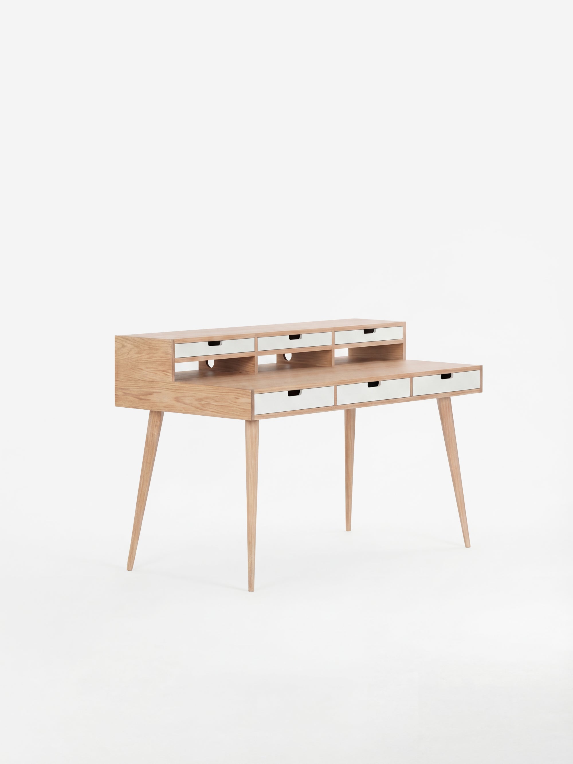Wooden writing desk with slim legs and multiple drawers, set against a white background.