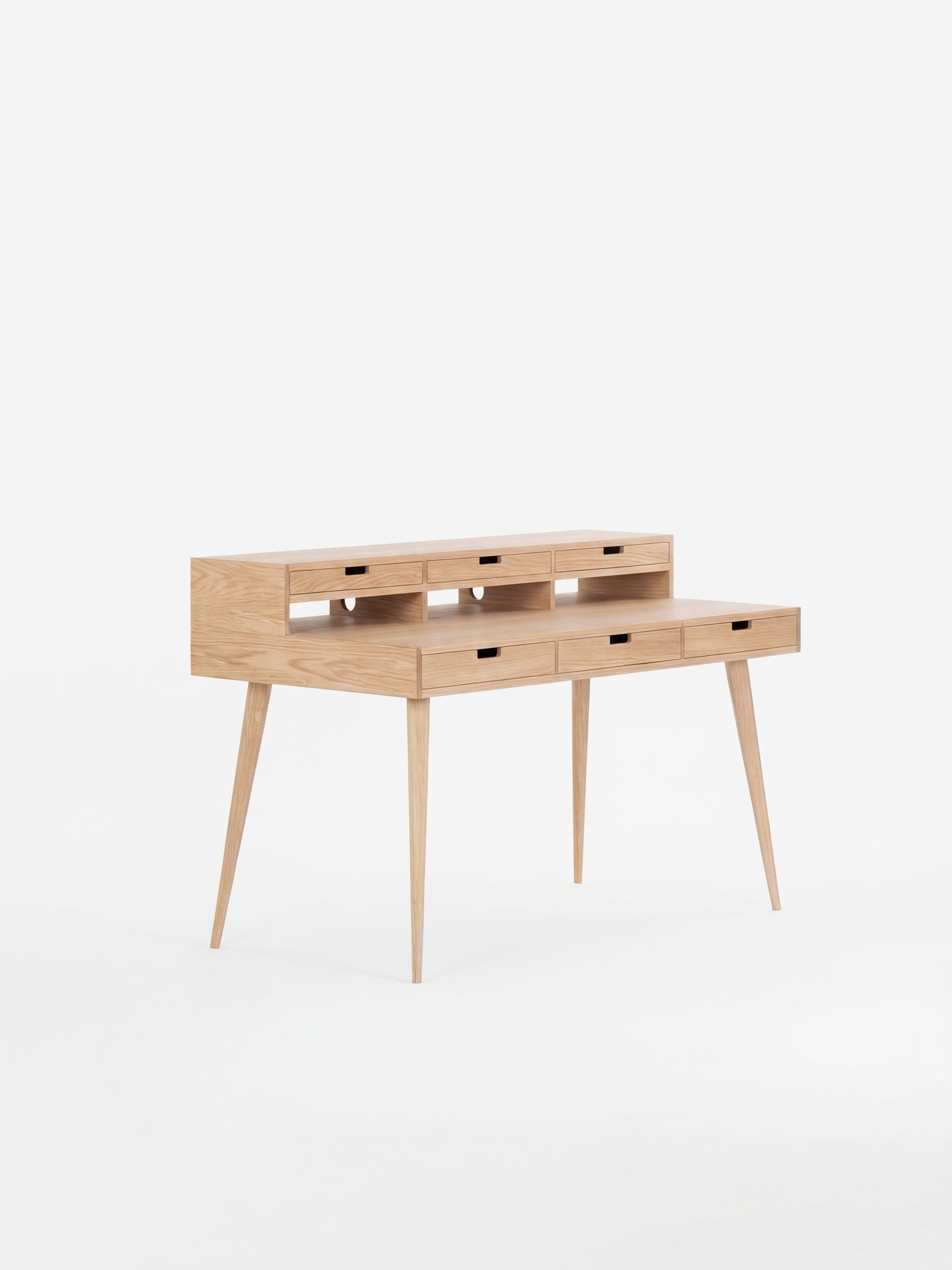 Wooden writing desk with slim legs and multiple drawers, set against a white background.