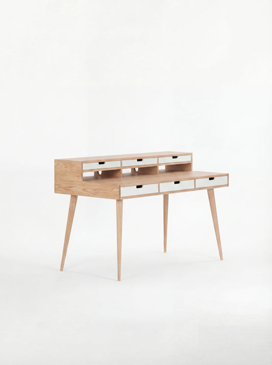 Wooden writing desk with slim legs and multiple drawers, set against a white background.