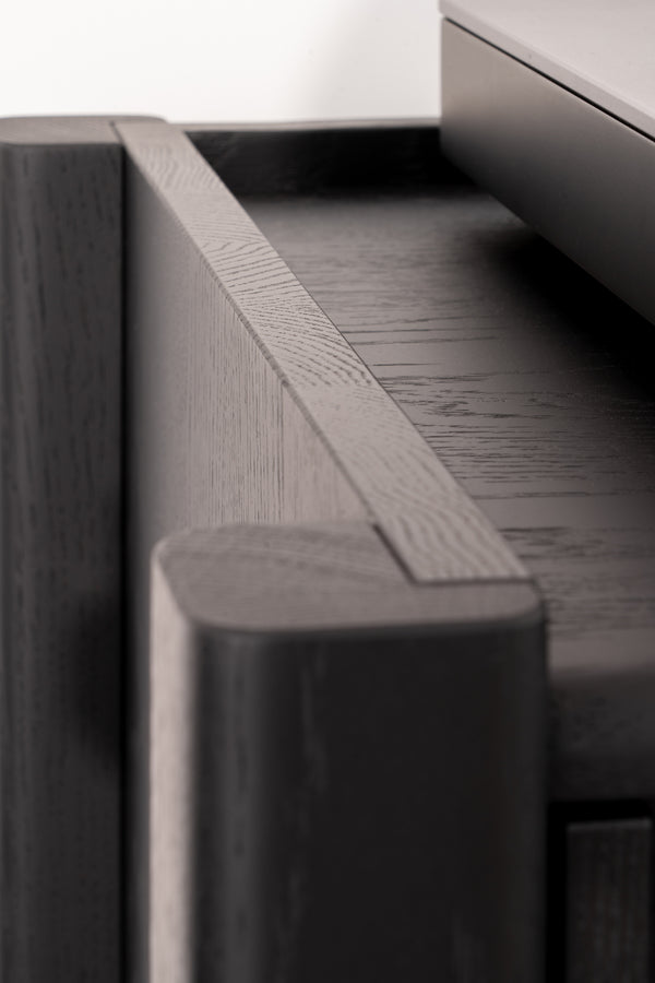 Close-up of a modern, dark wooden cabinet's corner with clean lines and smooth finish.