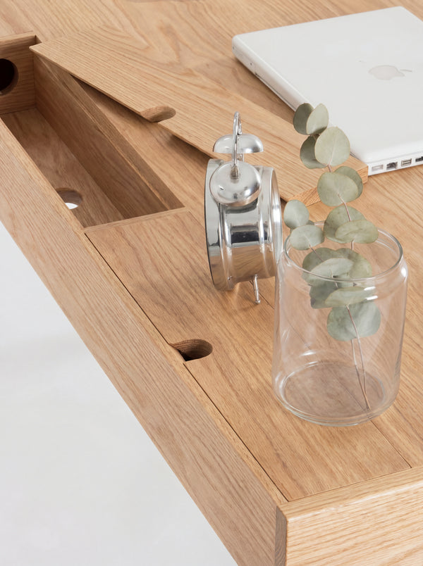 HEIM 140 desk in oak wood, one cable flap lifted above a compartment with a round hole, viewed from above