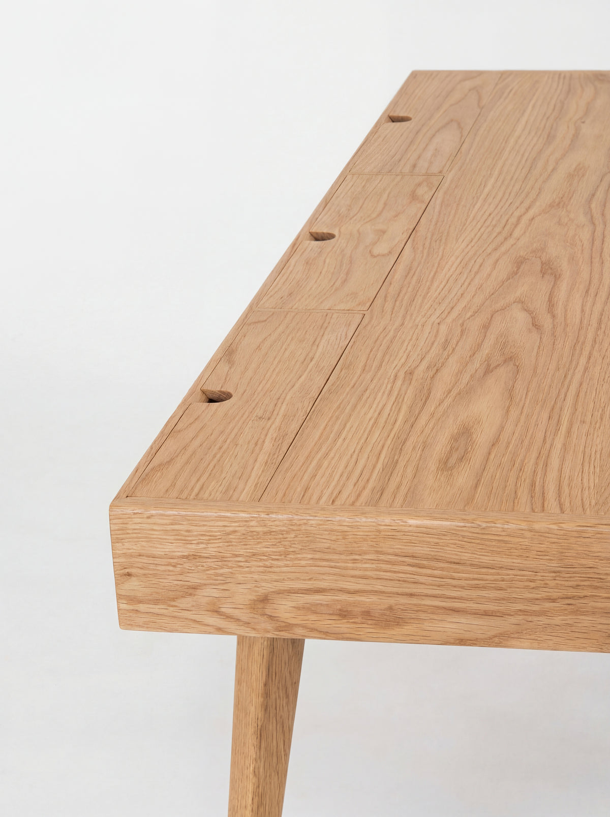 HEIM 140 desk in oak wood, close-up from above of three closed cable flaps with semicircular notches