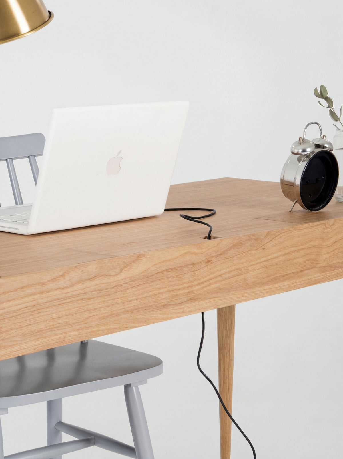 HEIM 140 desk in oak wood, close-up of a laptop cable passing through the notch in a closed cable flap
